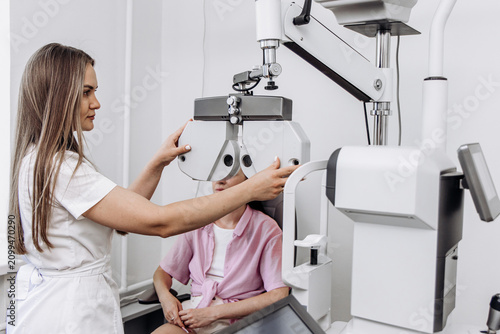 Foto Ophthalmologist preparing vision testing equipment before an eye examination