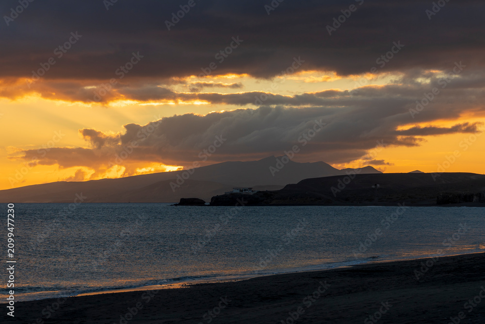 Obraz premium Fuerteventura island Canary islands Spain. Sunset view Tarajalejo beach, located in the municipality of Tuineje in southern Fuerteventura, is a semi-urban beach with black volcanic sand and pebbles, 