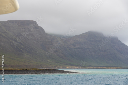 Lanzarote island in green in an unususaly rainy winter  province of Las Palmas Canary islands Spain Cliffs of northern Lanzarote from a boat sailing towards La Graciosa in the Chinijo Archipelago.