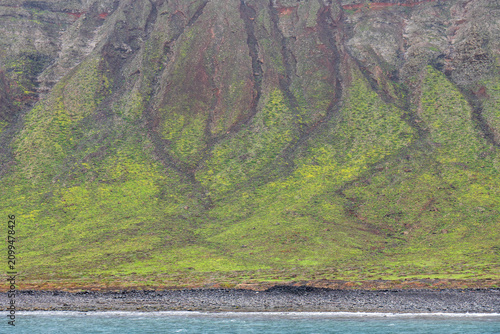 Lanzarote island in green in an unususaly rainy winter  province of Las Palmas Canary islands Spain Cliffs of northern Lanzarote from a boat sailing towards La Graciosa in the Chinijo Archipelago.