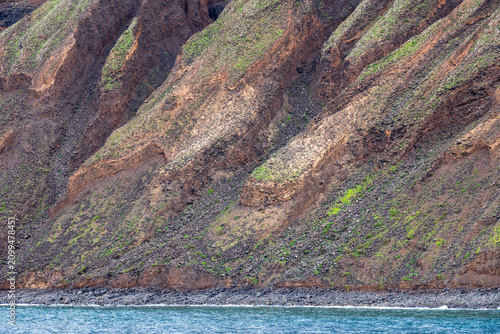 Lanzarote island in green in an unususaly rainy winter  province of Las Palmas Canary islands Spain Cliffs of northern Lanzarote from a boat sailing towards La Graciosa in the Chinijo Archipelago.