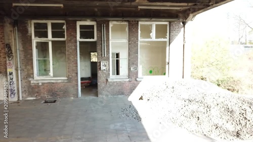 A sideways drone shot showing the former office buildings of an abandoned train station in Belgium. A busy station long time ago and now an urbex location