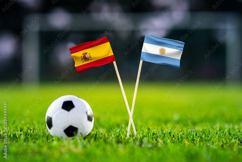 Fototapeta premium Spain vs Argentina, Final, national flags before international football match, football on green grass with stadium in the background, East Rutherford, July 19, 2026.
