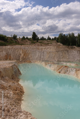 Vertical view of turquoise quarry lake and white clay formations
