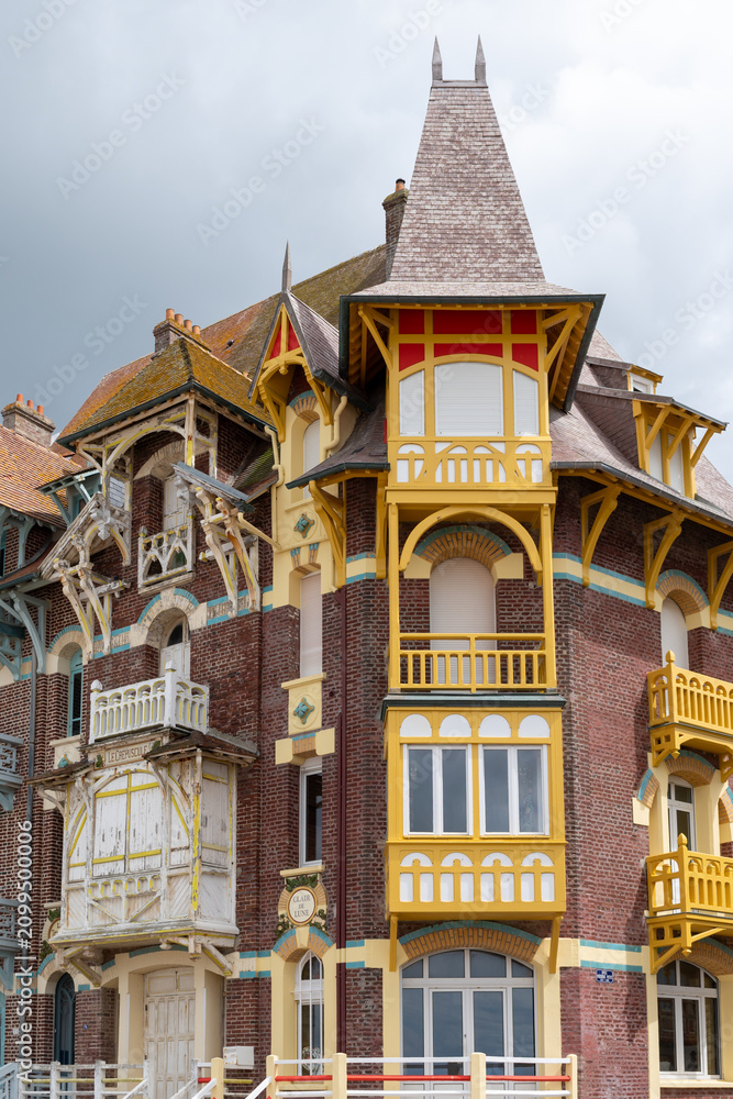 Fototapeta premium Houses of Mers-les-Bains, seaside town with 19th-century sea-bathing villas with colorful wooden balconies and white chalk cliffs, tourists destination in France