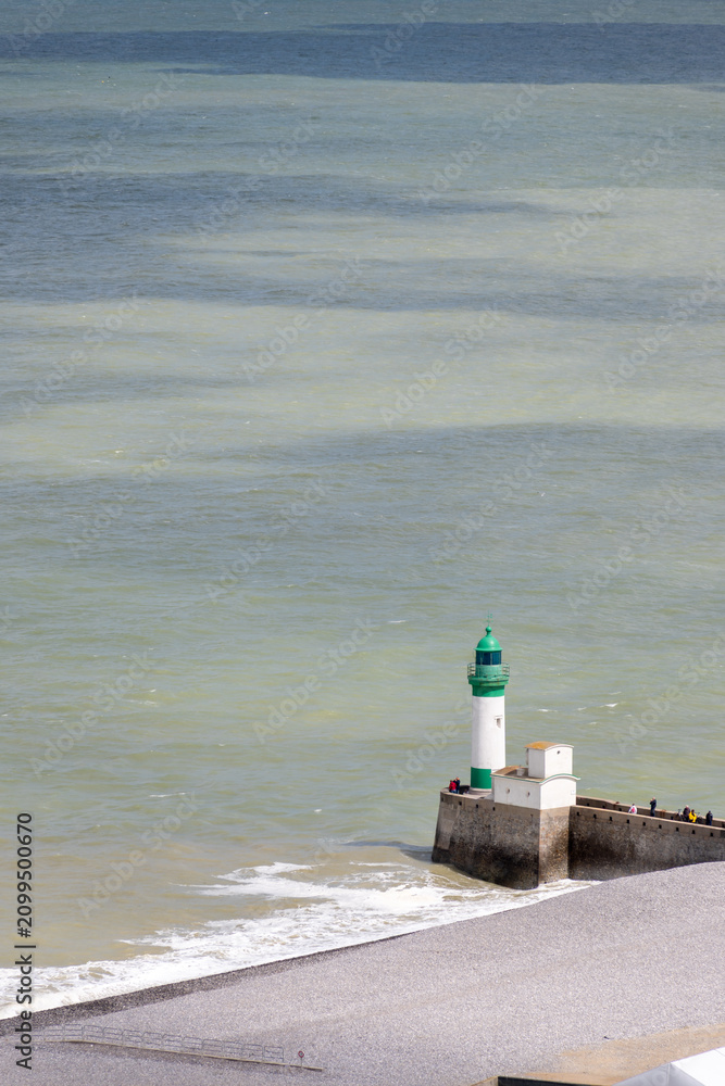 Fototapeta premium Views of ocean beach and colourful beach huts or cabins in Le Treport, seaside resort in Normandy, France, with white cliffs along English Channel, travel destination in France