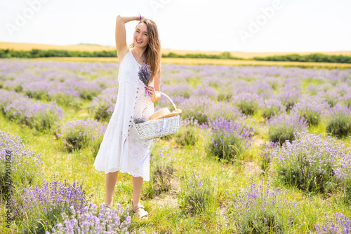 beautiful girl in a dress on a lavender field with a bouquet of flowers