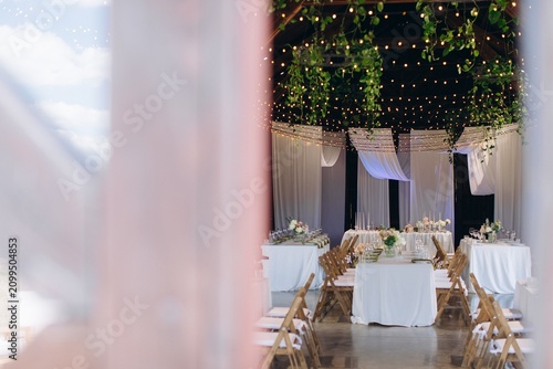 Wedding reception hall decorated with string lights and greenery