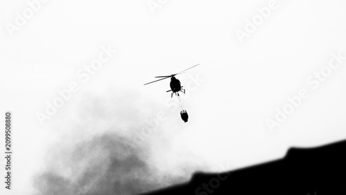 Helicopter Carrying Water Bucket in Flight