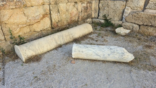 Athens, Greece - 22 June 2026. Two marble column shafts lie beside the masonry wall of the Early Christian Tetraconch, Basilica of Megali Panagia, near Hadrian's Library.
