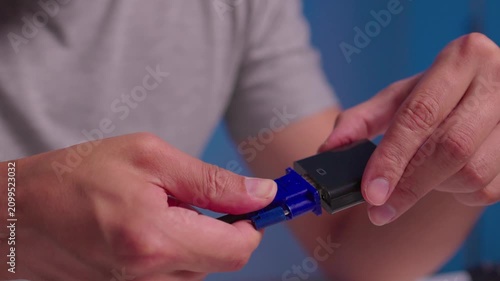Hands guiding blue braided cable plug into black rectangular connector housing with steady forward pressure, precise alignment, and secure insertion during hands on assembly work