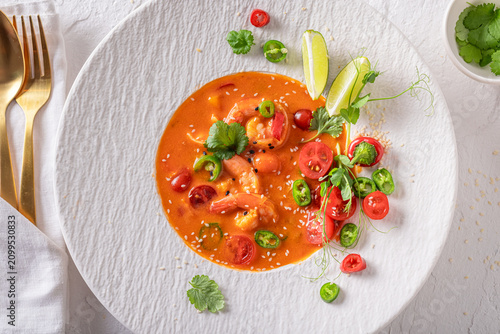 Professional and hot Thai soup decorated with sesame and coriander.