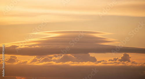 Lenticular clouds at sunset sky