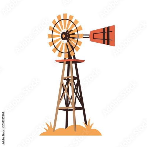 A rustic windmill stands tall in a field of dry grass on a bright day.
