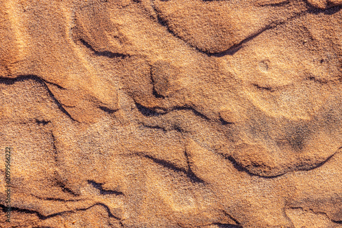 Rough and textured ground surface of dry desert sand, organic earthy tones,