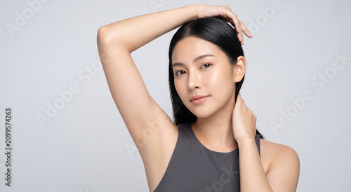 Beautiful Young Asian Woman with Smooth Skin and Clean Underarm Raising Arm for Skincare and Beauty Concept