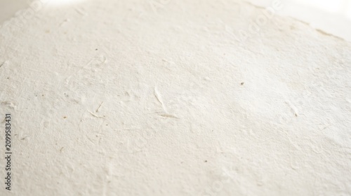 Close up view of textured handmade paper background with soft natural light