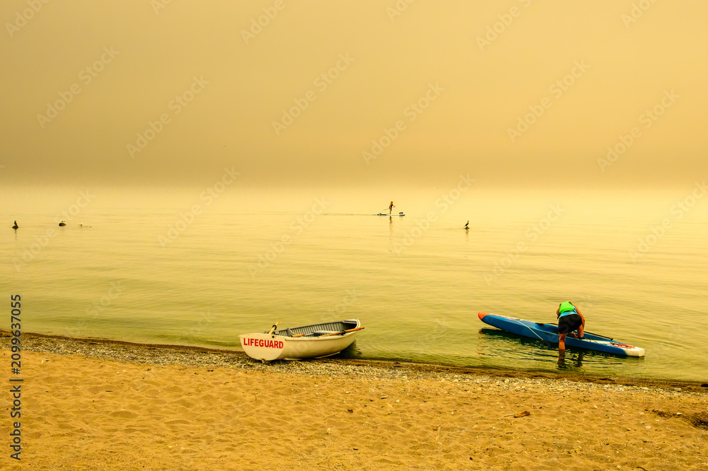 Obraz premium Paddleboarder Under Smoky Golden Sky