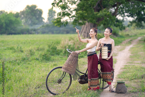 Two Beautiful Chiang Mai Women in Traditional Lanna Dress with Vintage Bicycle in Rural Countryside