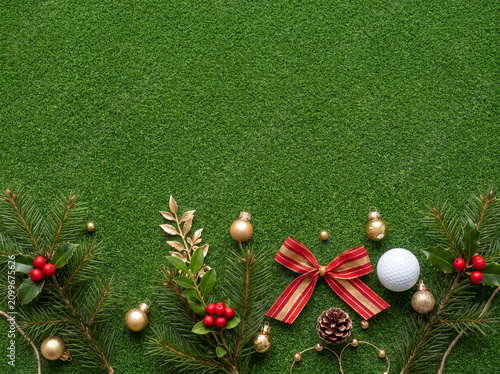 putting grass surrounded by evergreen branches, red berries, pinecones, elegant Christmas ornaments, festive ribbon, and a single white golf ball decorating only the outer border.