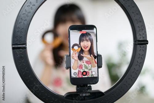 スマホでスイーツ撮影をする日本人女性