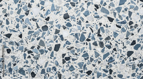 Blue and white terrazzo surface texture with irregular stone fragments background