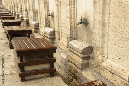Ablution area with taps and stools at mosque in Turkey