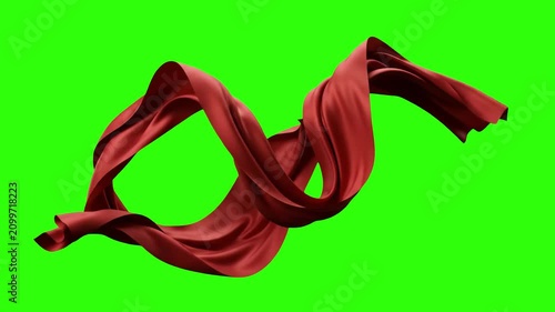 A luxurious red silk or satin ribbon floats and waves smoothly in a continuous loop. This elegant fabric motion graphic is isolated on a chroma key green screen.