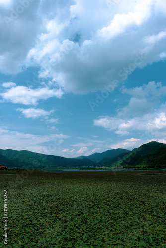 Canvas Print Mountain lake under blue sky with white clouds