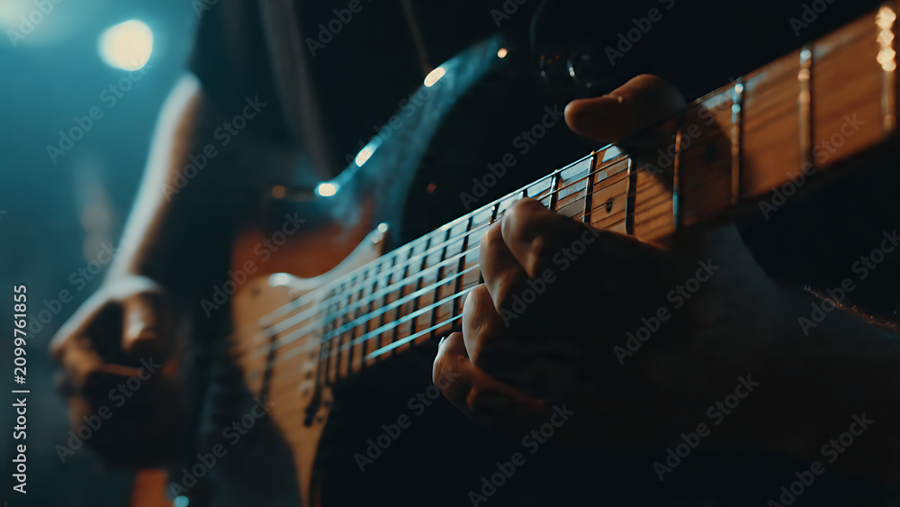 Fototapeta premium Close-up of hands playing electric bass guitar.