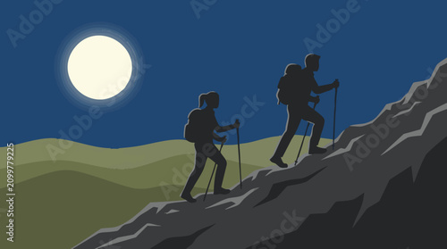 Silhouetted hikers climbing mountain at night under full moon and stars