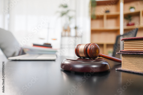 Justice and law concept.Male judge in a courtroom with the gavel, working with, computer and docking keyboard, eyeglasses, on table in morning light