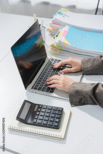 businessman working on desk office with using a calculator to calculate the numbers, finance accounting concept
