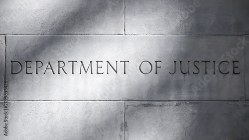Stone wall engraved with the words department of justice in capital letters