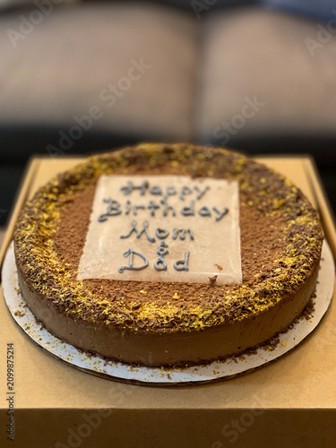 Personalized birthday cake prepared for parents with chocolate decorations and festive icing