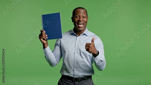 Confident Man Holding Blue Folder Giving Thumbs Up On Green Screen Background For Business And Education Success Concepts