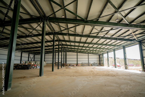 Inside a newly built industrial storage hall with open rolling doors.