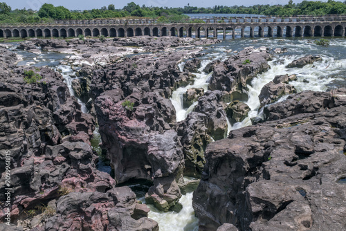 A high-angle shot of the naturally formed basalt rock potholes, locally known as Ranjan Khalge, carved over centuries by the Kukadi River in Nighoj, Ahmednagar district, Maharashtra, India.