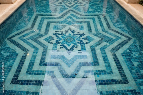 Luxury hotel swimming pool with beautiful geometric patterns, sophisticated resort scenery with star-shaped blue tiles