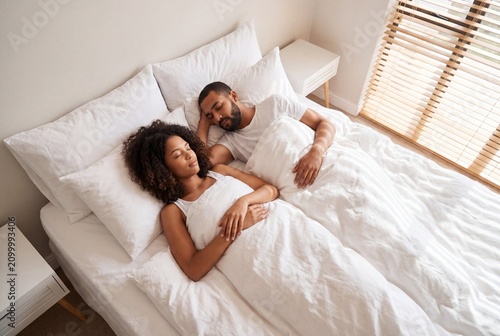 Young Biracial Couple Sleeping Peacefully in Bright White Linen Bed with Morning Light Filtering Through Blinds, Calm Aspirational Hotel-Quality Bedroom Scene