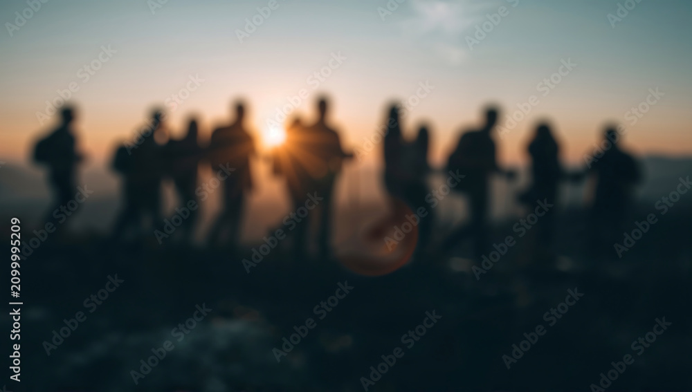 Fototapeta premium Generative AI depicts a group of people silhouettes against a sunset horizon