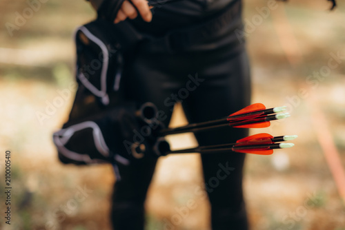 Fotografie Archer preparing multiple arrows with red fletching for outdoor target practice