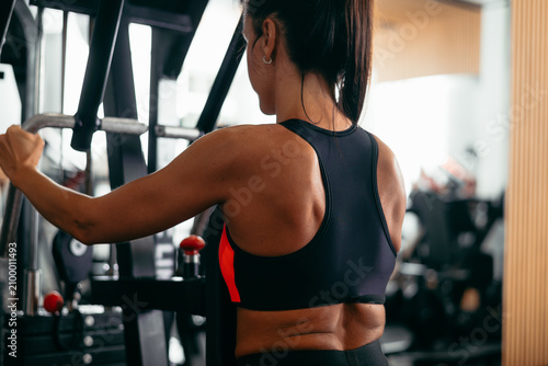 Cuadro en lienzo A woman is using a weight machine for strength training in a gym setting