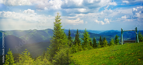 Forested mountains in a scenic landscape view and wooden swings