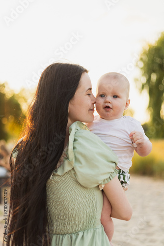 Tender moment between a mother and her baby at sunset outdoors