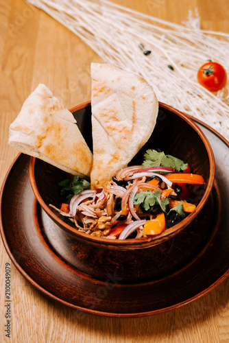 Obraz na plátně Fresh chicken salad with black beans and pita bread served in a rustic brown bow