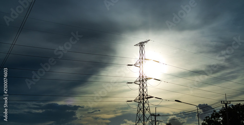 High voltage electric pole on storm sky dark background, line power electric hight voltage grid powerine transmission pylon generator station tower energy technology construction