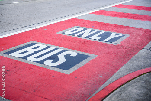 Red painted bus only lane marking prioritizing public transportation in Seattle, improving traffic flow and reducing urban congestion on city roads.