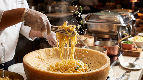 Gourmet catering station pasta tossed in parmesan cheese wheel