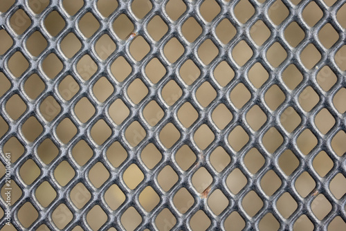 A detailed close up of a black metal mesh or grate with a repeating diamond pattern